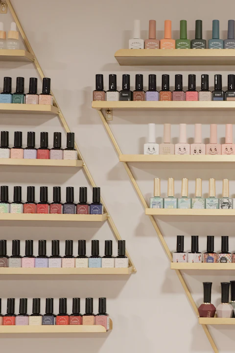 Repisas doradas con decenas de frascos de esmalte de colores